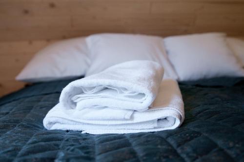 a pile of towels sitting on top of a bed at Jędroskowe Chatki in Witów
