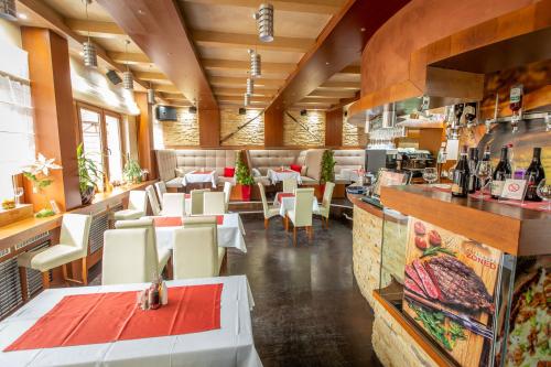 a restaurant with white tables and chairs and a bar at Zen apartman in Kopaonik