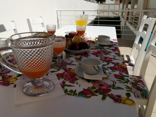 een tafel met twee glazen sap en een fruitschaal bij Villa Estrelinha in Nazaré