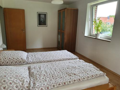 a bedroom with two beds and a window at Ferienwohnung an der Hasenburg in Lüneburg