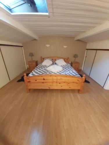 une chambre avec un lit en bois dans une pièce dans l'établissement Éblouissant appartement au calme d'une résidence avec piscine idéalement situé au pied du Colorado provençal dans le prestigieux Luberon, à Rustrel