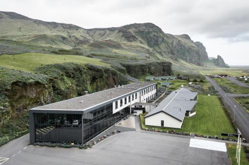 una rappresentazione di un edificio con montagne sullo sfondo di Hotel Vík í Mýrdal a Vík