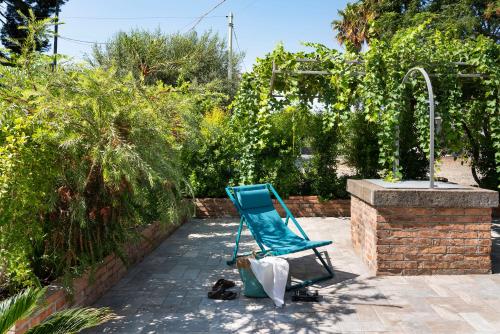 a blue lawn chair sitting next to a fountain at Suasor in Acireale