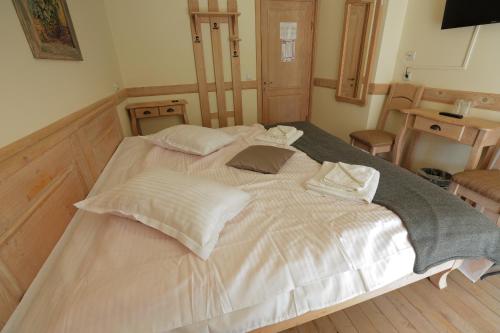 a large white bed in a room with a table at La Ferma Veche Bogdana in Bogdana