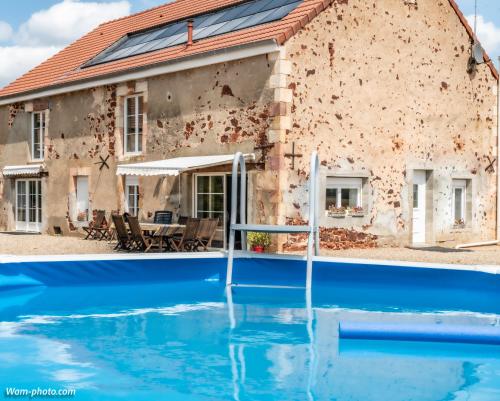 une maison avec une piscine devant dans l'établissement Gîte La Fontagrille, à Épineuil-le-Fleuriel