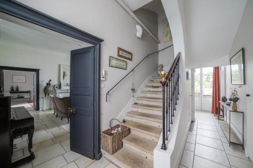a hallway with a blue door and stairs in a home at La Maison D'Hôtes Nantes Centre in Nantes