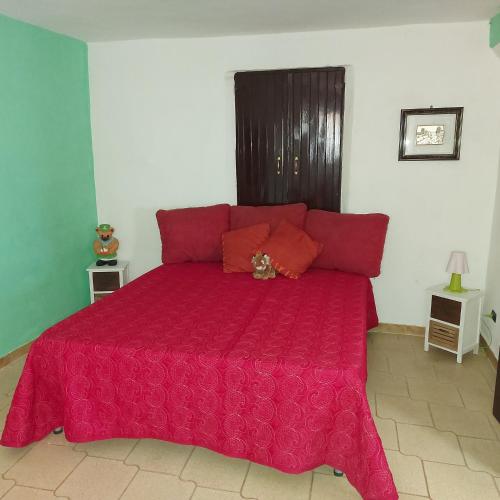 1 cama roja con edredón rojo en una habitación en Casale di Pesche, en Pesche