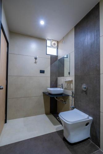 ein Badezimmer mit Toilette und Waschbecken in der Unterkunft Hotel Gold Star in Rajkot