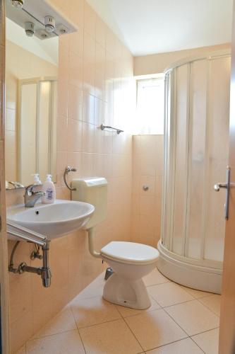 a bathroom with a toilet and a sink and a shower at Apartments Lonić in Kukljica