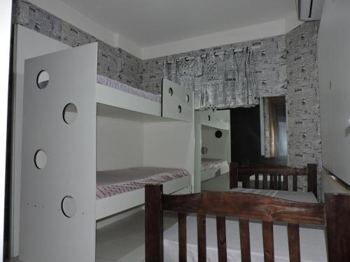 une pièce avec un banc en bois et un mur dans l'établissement Floresta - Enseada Guarujá, à Guarujá