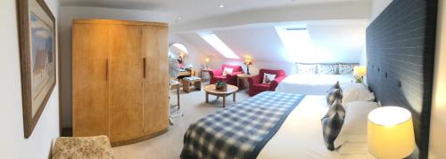 パースにあるThe Townhouseのベッドとリビングルームがあるホテルの部屋
