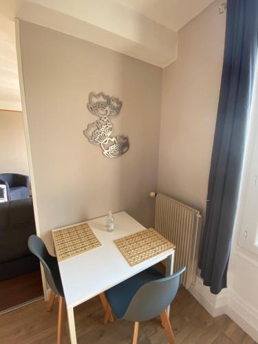 uma pequena mesa branca e cadeiras num quarto em L’appartement de Rose em Seurre