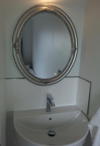 a bathroom with a mirror above a sink at Guesthouse Geldingaholt in Árnes