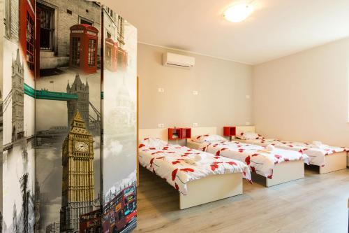a room with four beds and a mural of big ben at Hostel Sunset in Zadar