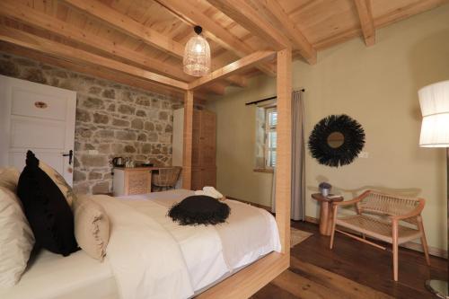 a bedroom with a bed and a stone wall at Perlacia Hotel Adatepe in Adatepe