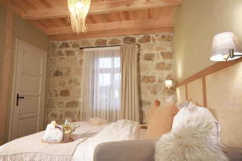 a bedroom with a large bed with a stone wall at Perlacia Hotel Adatepe in Adatepe