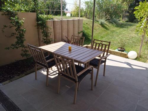 a wooden table and chairs on a patio at Appartamento seminterrato Villa Sveva Franciacorta in Ome
