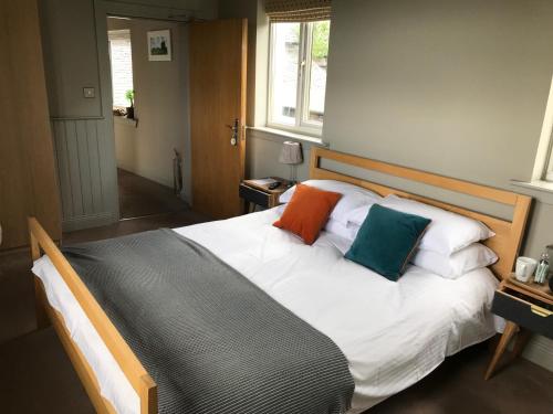 a bed with colorful pillows on it in a room at The Cross Keys in Kippen in Kippen