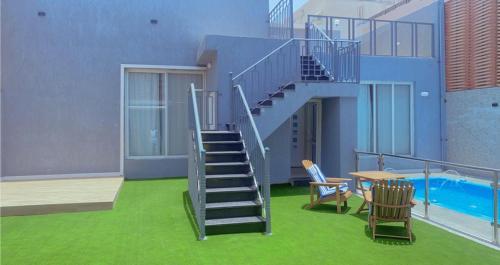 a house with a staircase and a table and chairs at شاليه دانة بحر in Yanbu