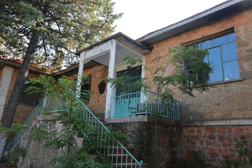 a brick house with a window and a balcony at Perlacia Hotel Adatepe in Adatepe