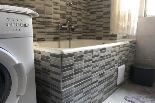 a bath tub in a bathroom with a washing machine at Apartman Kadić Senj in Senj