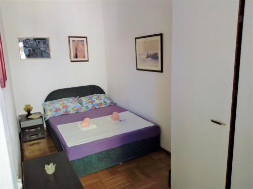 a small bedroom with a bed and a table at Una's House of Joy in Krapanj