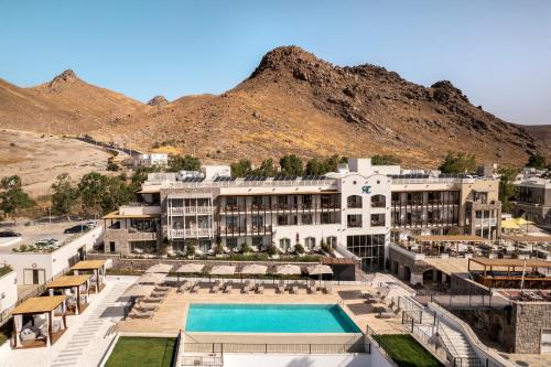 a resort with a pool and mountains in the background at Radisson Collection Hotel, Bodrum in Akyarlar
