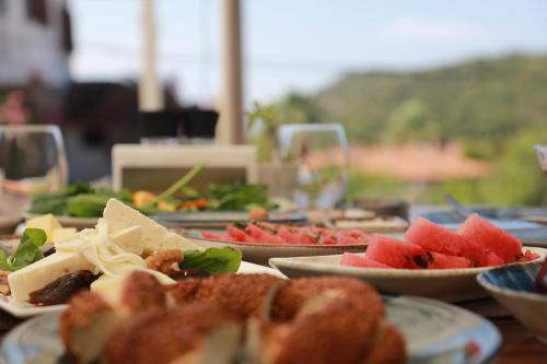 a table with plates of food on top at Perlacia Hotel Adatepe in Adatepe