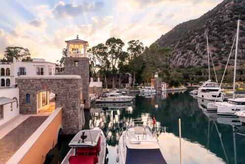 a group of boats in a marina with a clock tower at Radisson Collection Hotel, Bodrum in Akyarlar