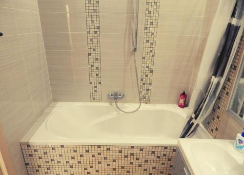 a bath tub with a shower and a sink at Апартаменти в Новому Будинку біля Софіївського Парку in Umanʼ