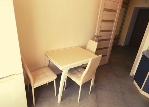 a small white table and two chairs in a room at Апартаменти в Новому Будинку біля Софіївського Парку in Umanʼ
