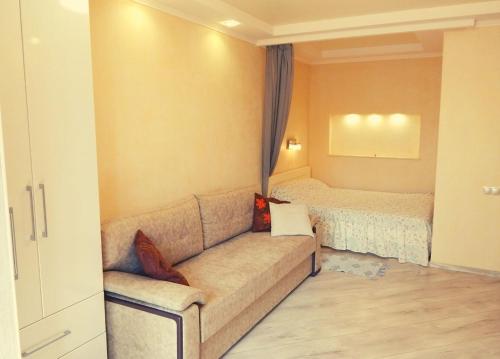 sala de estar con sofá y cama en Апартаменти в Новому Будинку біля Софіївського Парку, en Uman