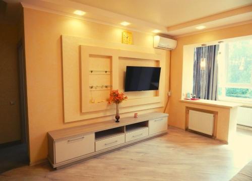 a living room with a television on a wall at Апартаменти в Новому Будинку біля Софіївського Парку in Umanʼ