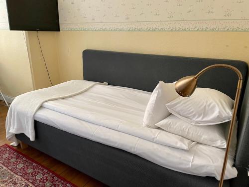 a bed with a white comforter and pillows at Pensionat Odengatan 38 in Stockholm