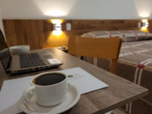 a cup of coffee sitting on a table with a laptop at Pinda Palace Hotel in Pindamonhangaba