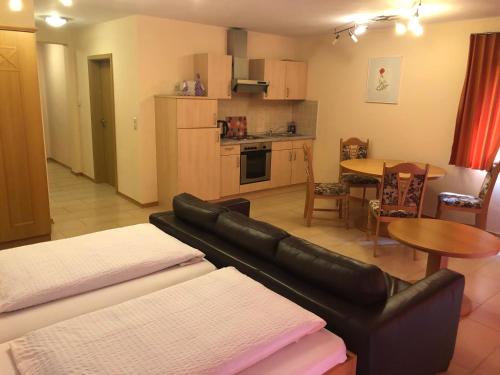 a living room with a couch and a kitchen with a table at Hotel Berghof in Biersdorf