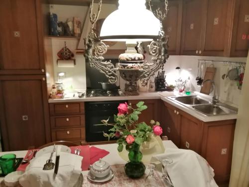una cocina con una mesa con un jarrón de flores. en B&B da Paolo con vista Lago di Garda, en San Zeno di Montagna