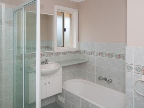 a bathroom with a sink and a bath tub and a mirror at Aquarius Townhouse in Hawks Nest