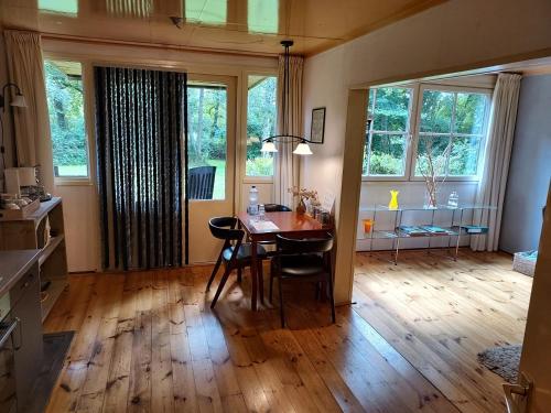 a living room with a table and chairs and windows at De Vuurplaats in Drachten