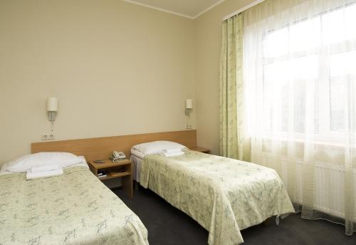 a hotel room with two beds and a window at TOSS Hotel in Rīga