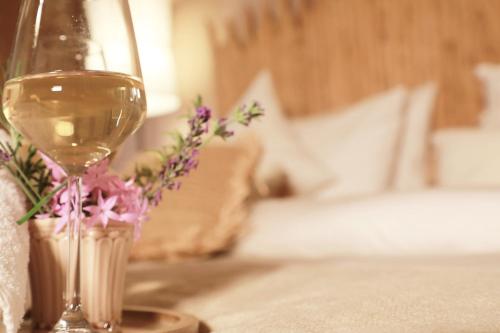 a glass of wine sitting on a table with flowers at Perlacia Hotel Adatepe in Adatepe
