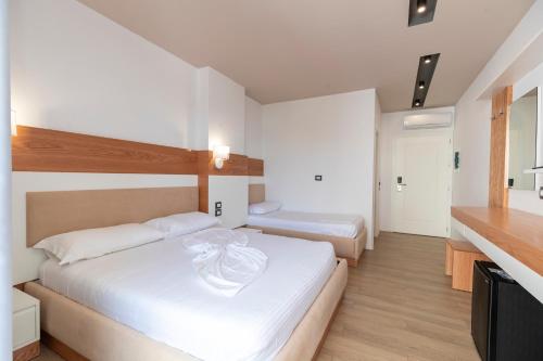 a hotel room with two beds and a kitchen at Ventus Hotel in Ksamil