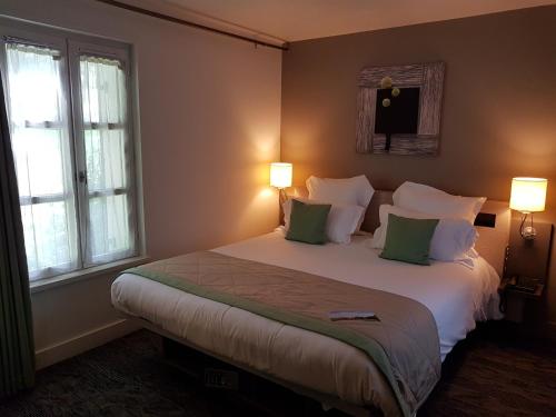 a bedroom with a large bed with green pillows at Le Cap Hornu in Saint-Valery-sur-Somme