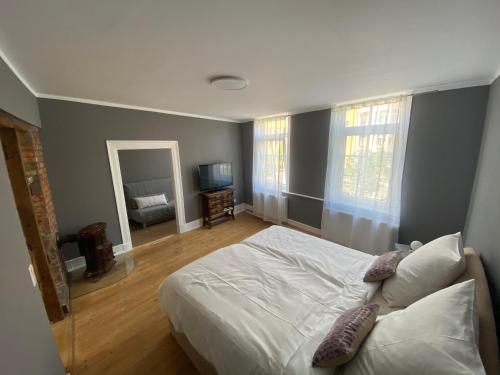 a bedroom with a white bed and a mirror at Altstadt Fereienwohnung Hameln in Hameln