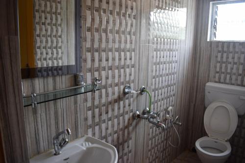 a bathroom with a sink and a toilet at The Imperial Hotel in Rādhākishorepur