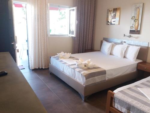 a bedroom with a bed with two white flowers on it at Hotel Alexandros II in Toroni