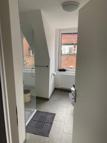 a bathroom with a glass door and a window at Altstadt Fereienwohnung Hameln in Hameln