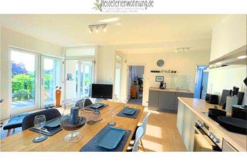 a living room with a dining table and a kitchen at heideferienwohnung - die neue Ferienwohnung in Walsrode