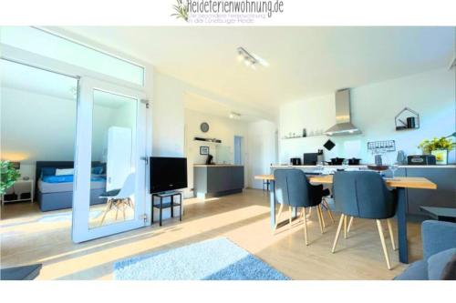 een keuken en een woonkamer met een tafel en stoelen bij heideferienwohnung - die neue Ferienwohnung in Walsrode