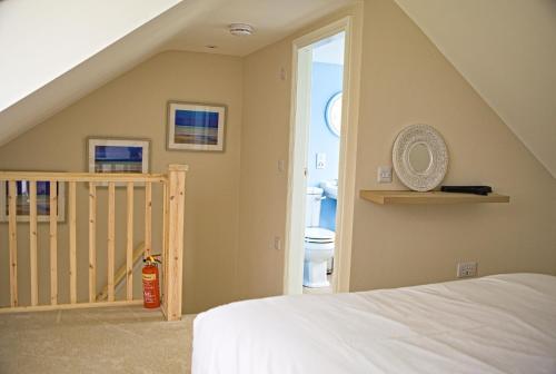 a room with a bed and a bathroom with a toilet at Arthur's Cottage in Dumfries